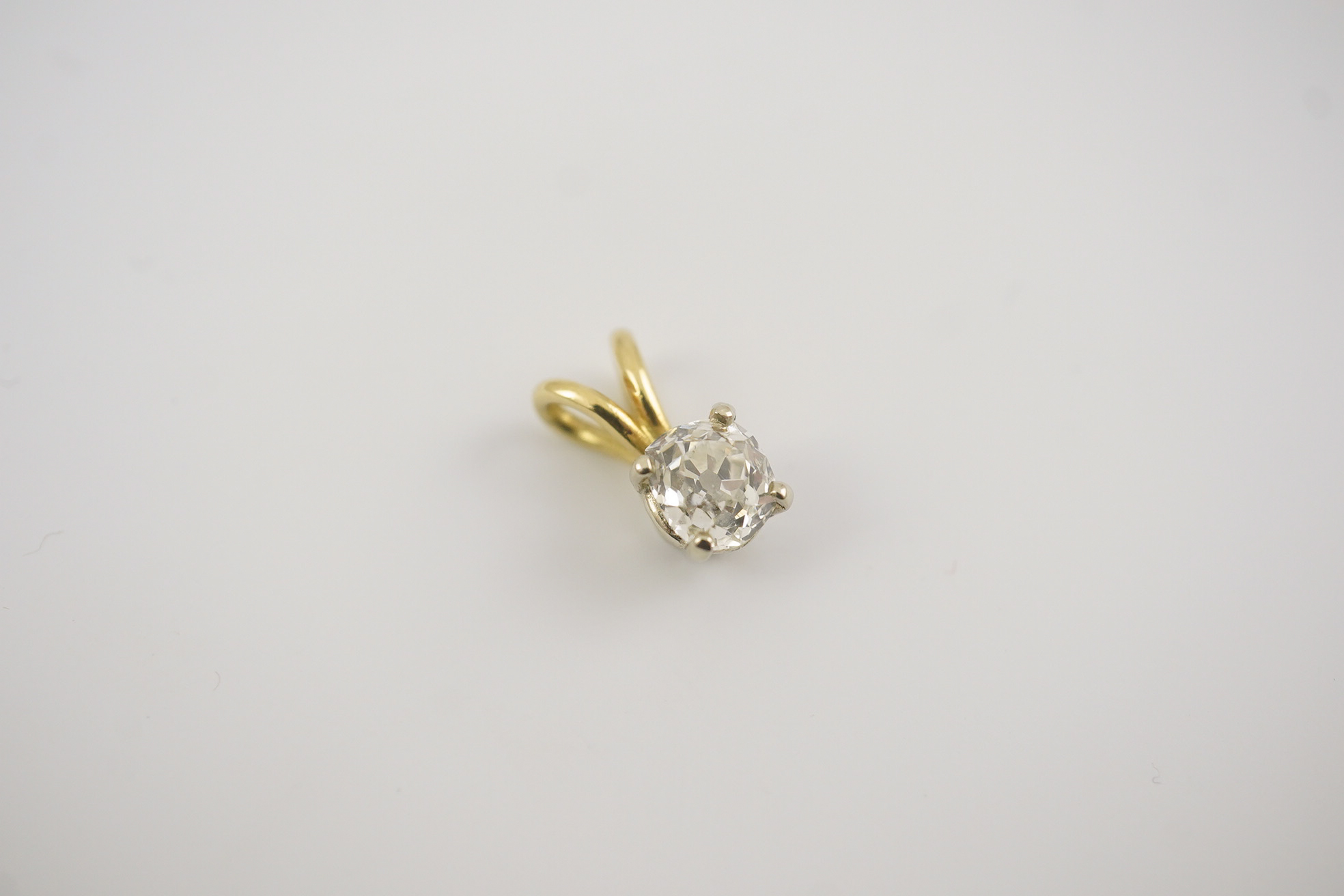 A gold and solitaire diamond set small pendant